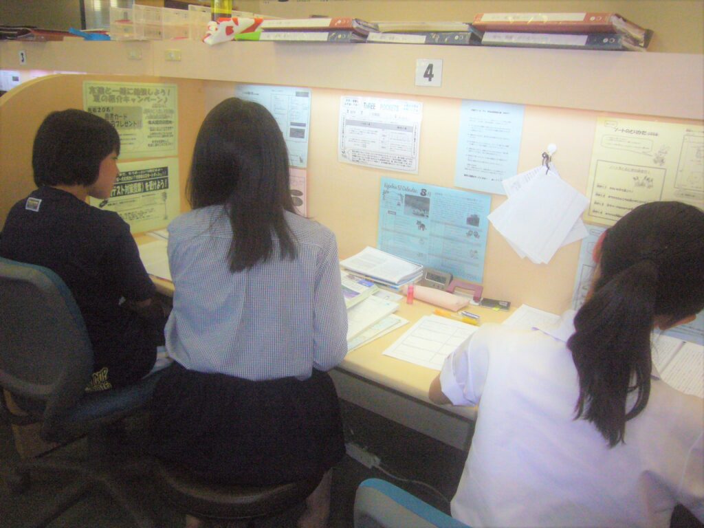 1対2の授業風景。真ん中の女性講師は左の女子生徒に指導しており、右の生徒は問題演習を行っている。